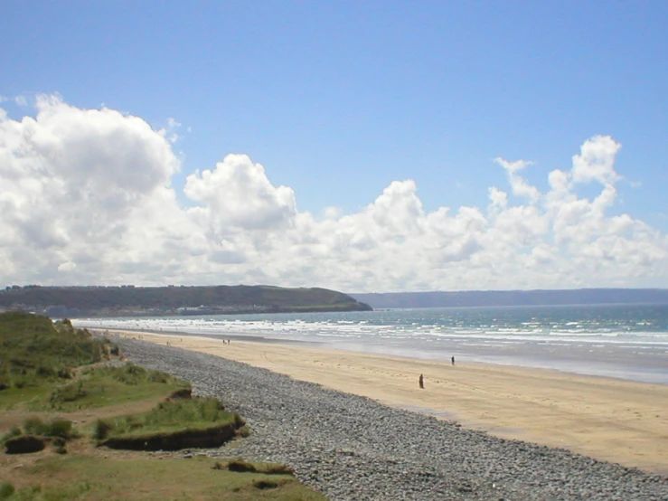 a rocky beach with a sky filled with clouds