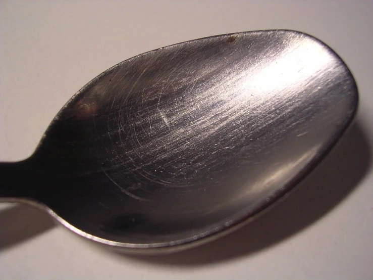 an old spoon sits on a table top