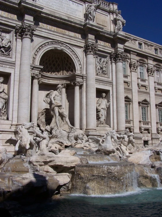 a couple of statues near a water fountain