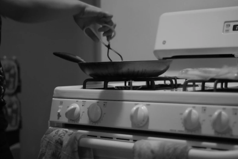 a person using an iron to cook food in a pan on the stove