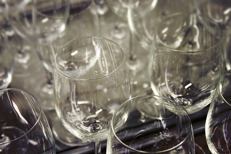 many wine glasses lined up in rows on a table