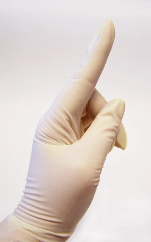 an open hand in a white glove holding a small toothbrush