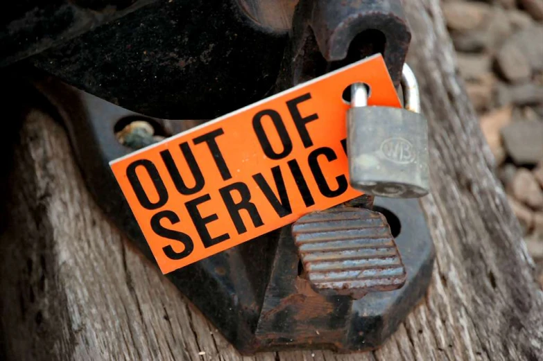 orange out of service sign sits on an old fence