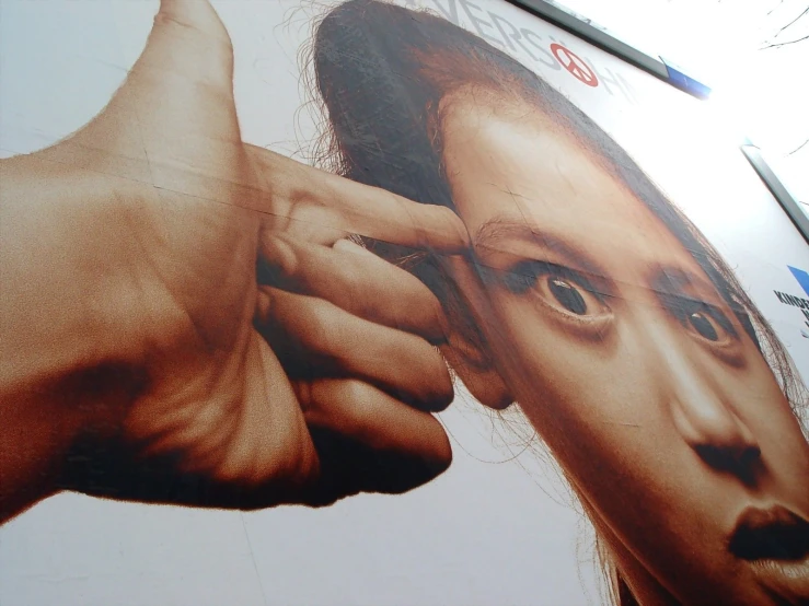 a picture of the face of a person and the hand of a hand on a sign