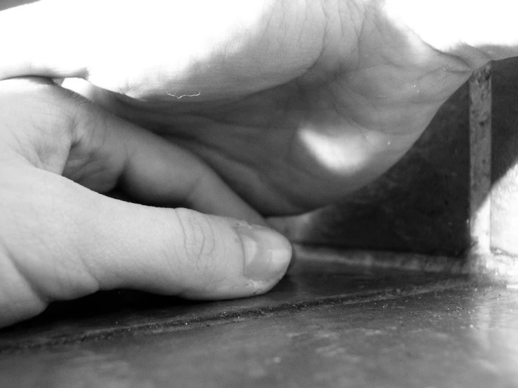 a persons fingers on a table in a dark room