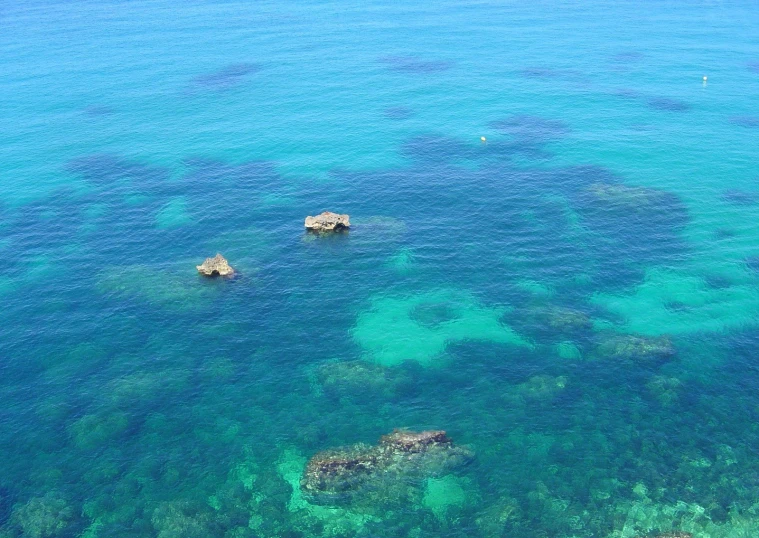 a blue ocean with lots of rocks in it