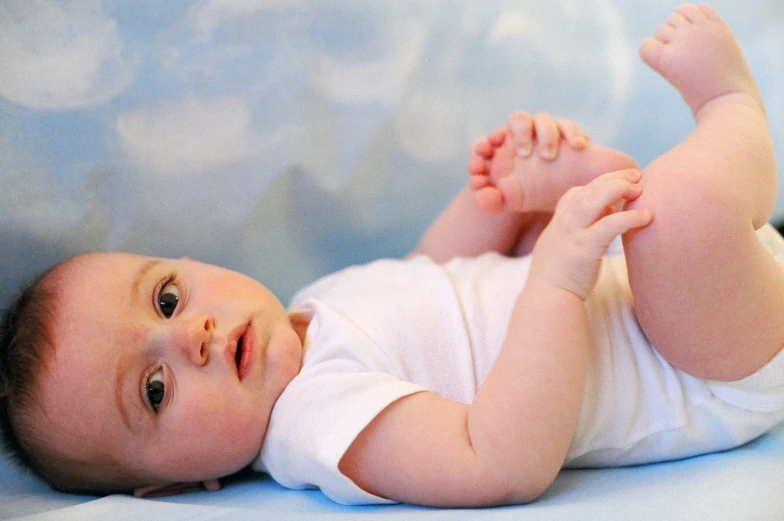 a baby that is laying down on his back