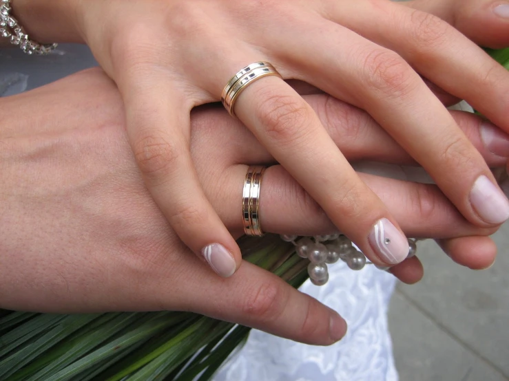 a couple in wedding clothes holding hands together