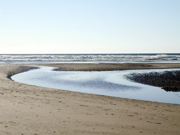 there are footprints in the sand near the water