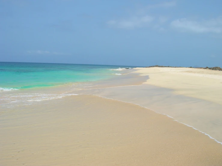 white sand beach line and clear blue ocean