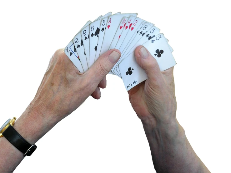 playing cards are held up by someone's hands