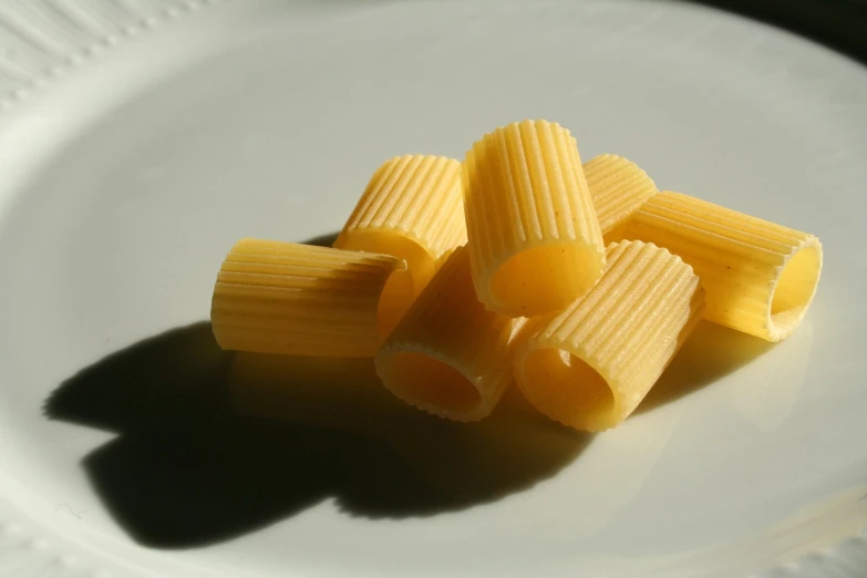 a bunch of yellow pasta on a white plate