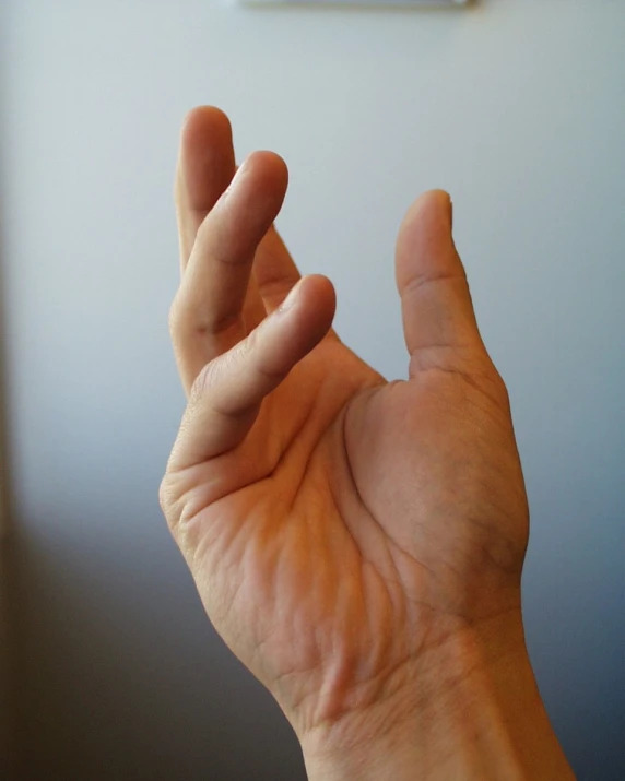 a hand with its hand up in front of a clock