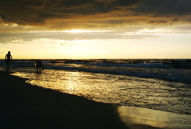 there is a man and woman walking along the beach