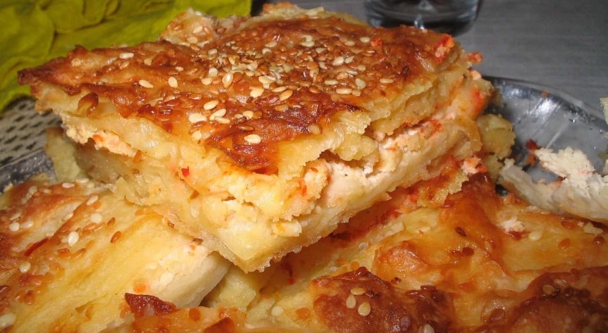 sliced up pizza sitting on a glass plate on a table