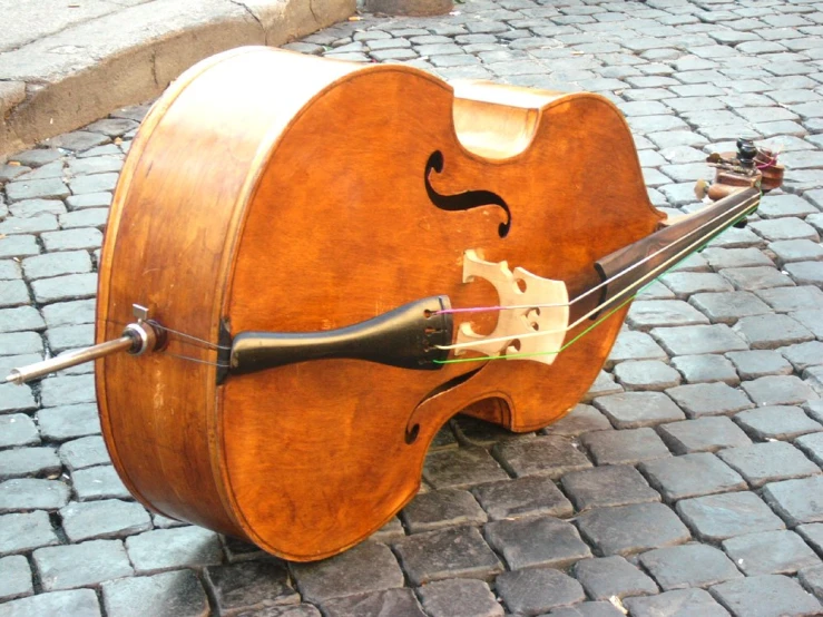 an acoustic electric instrument attached to a brick walkway