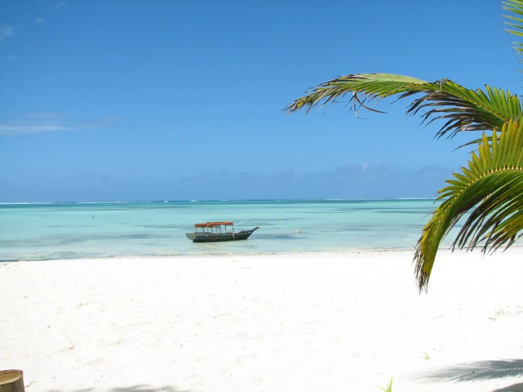 a boat sitting on the beach near the ocean