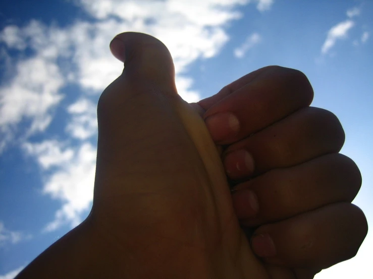 a hand reaching up into the sky with a large, pointed foot