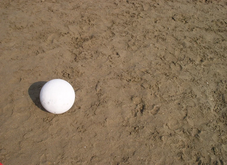 a frisbee sits in the sand on a beach