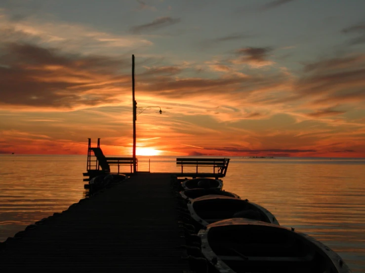 the sun is setting over a boat dock