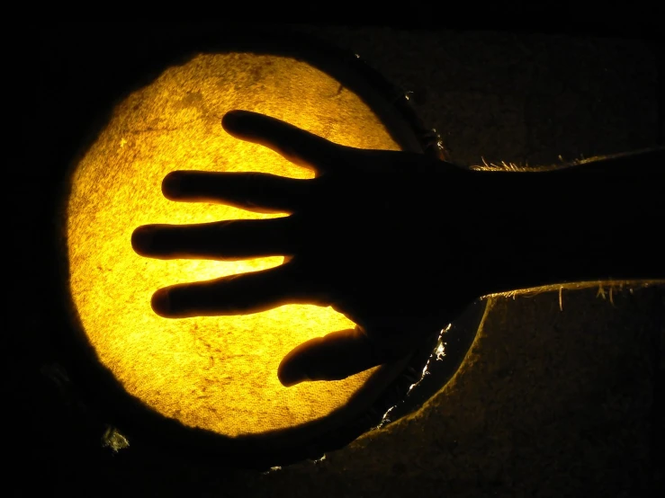 a person's hand is glowing in the dark with a yellow light