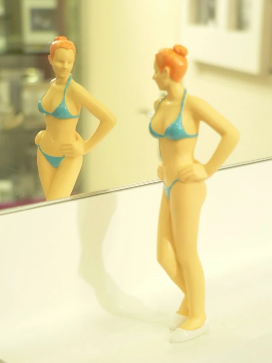 the little toy female body is shown in the reflection of the mirror