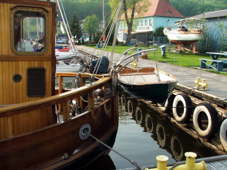 small tug boat tied to a wooden dock