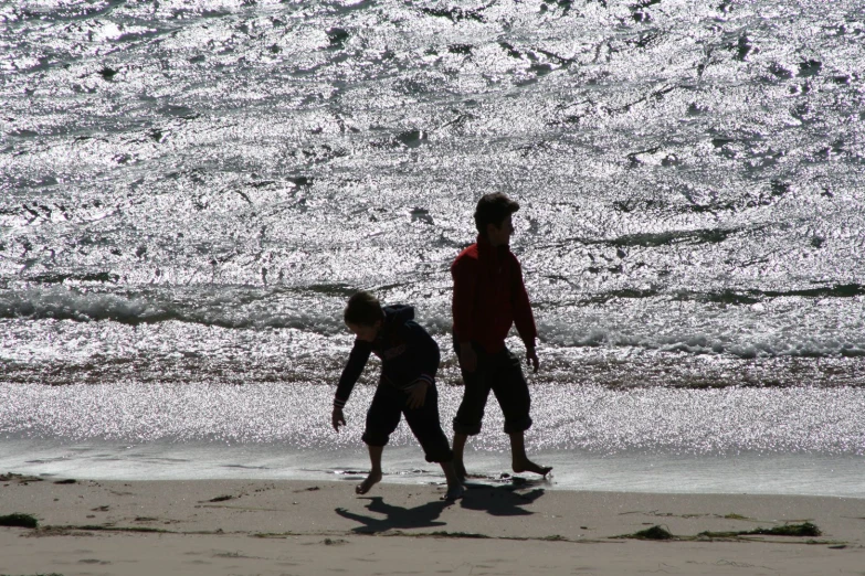 a young man and woman are running on the beach