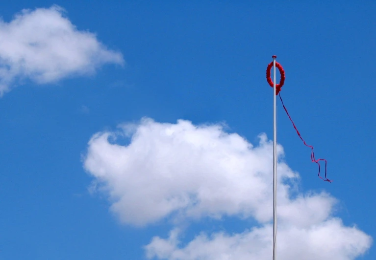 a red circular decoration on a flag pole