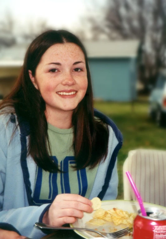 a woman sitting at a table eating food