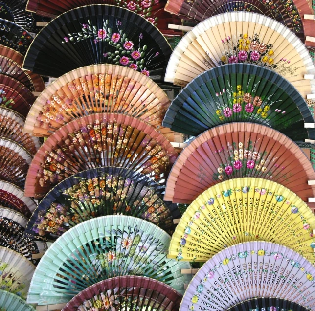 many colorful asian fans on display in a store