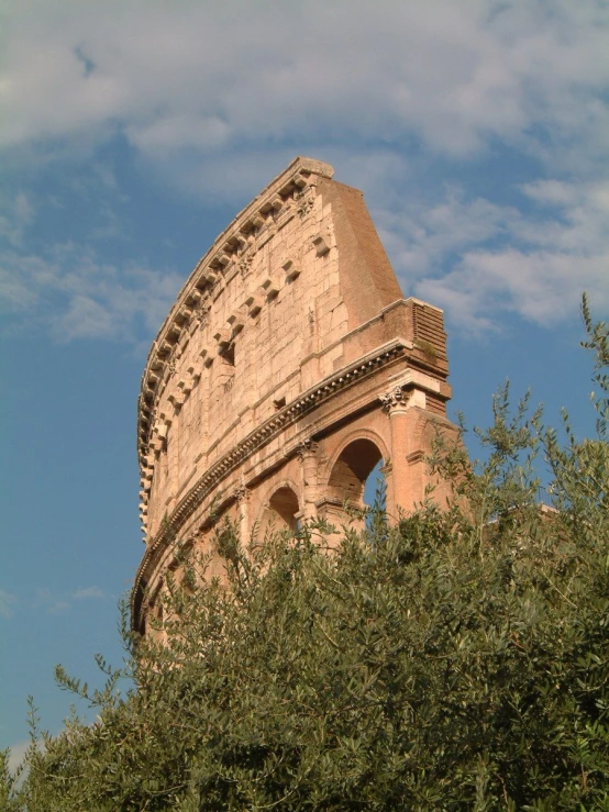 a stone building surrounded by greenery on top of a blue sky