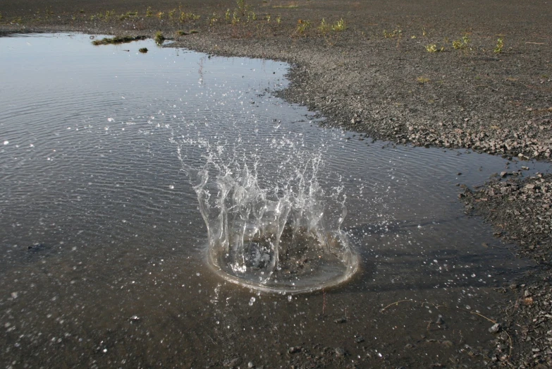 a dle of water pouring into a small pond