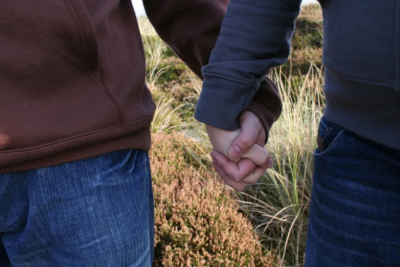 a couple hold hands while holding each other's hands