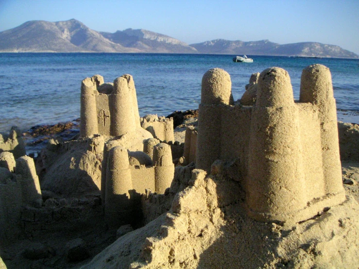 a boat in the ocean near sandcastles