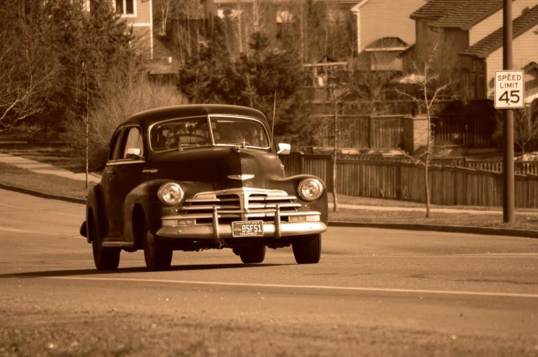 a black and white po of an old car driving down a road