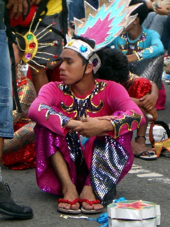 people in costume sit and stand on the street