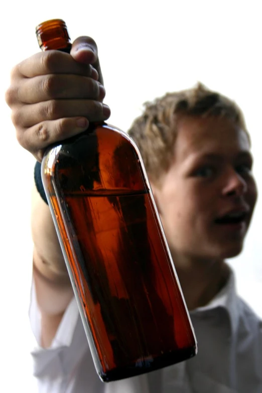 man holding up an empty bottle in the sun