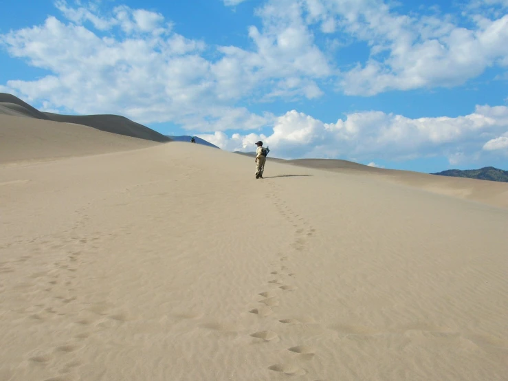 there is a man standing in the middle of a desert