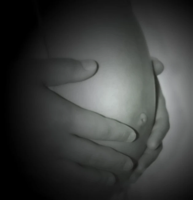 a pregnant mother holding the baby bump of her husband