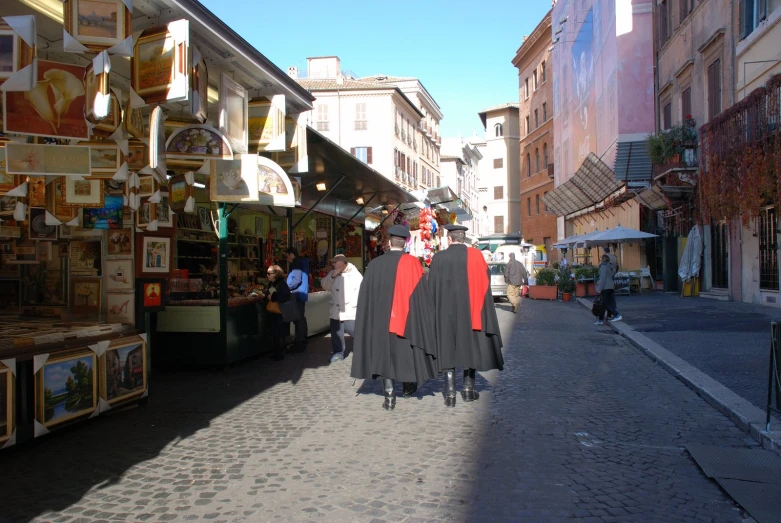 people dressed in costumes walking down a cobblestone street