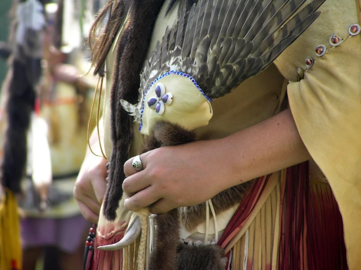 two people in native garb holding animals