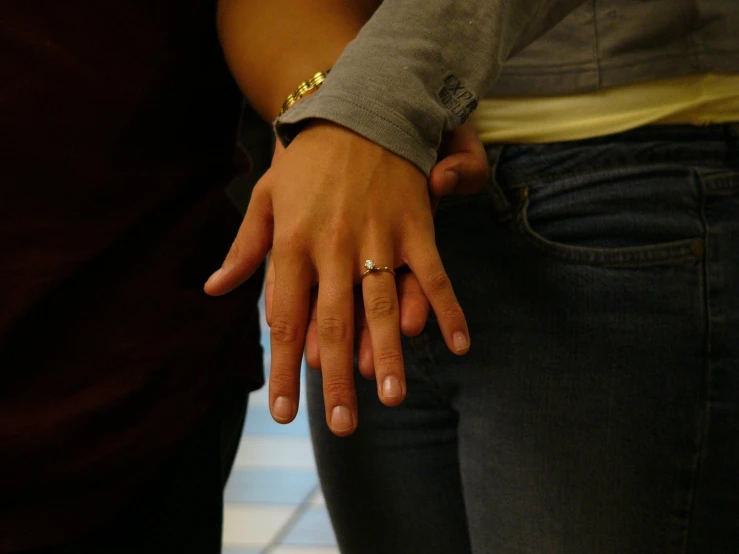 a close up of two people holding hands on their fingers