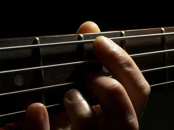 someone playing a guitar in the dark on their fingers
