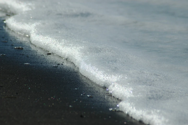 the sand is white and gray with some foam