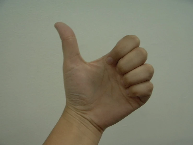 hand giving a thumbs up sign with a white background