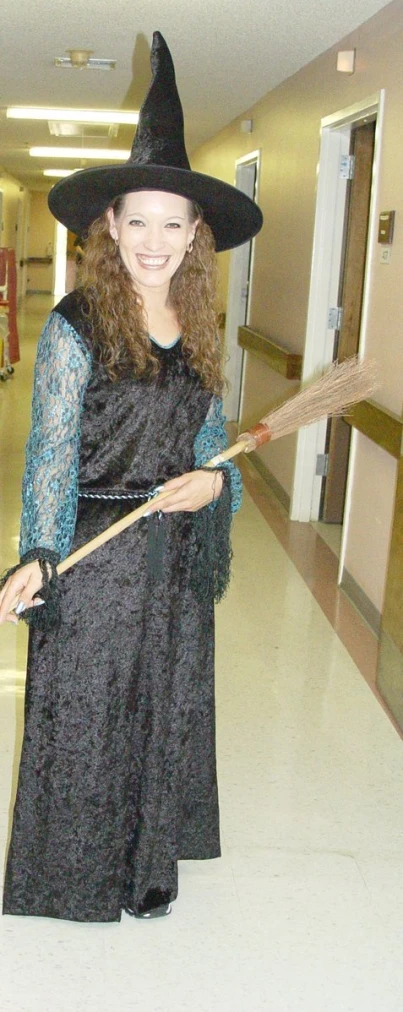 the woman dressed up as a witch holding a broom