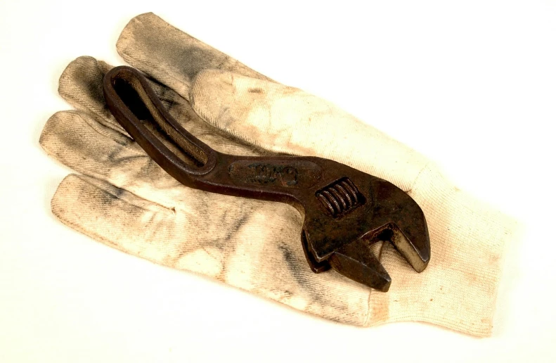 a brown pliers on top of white cloth