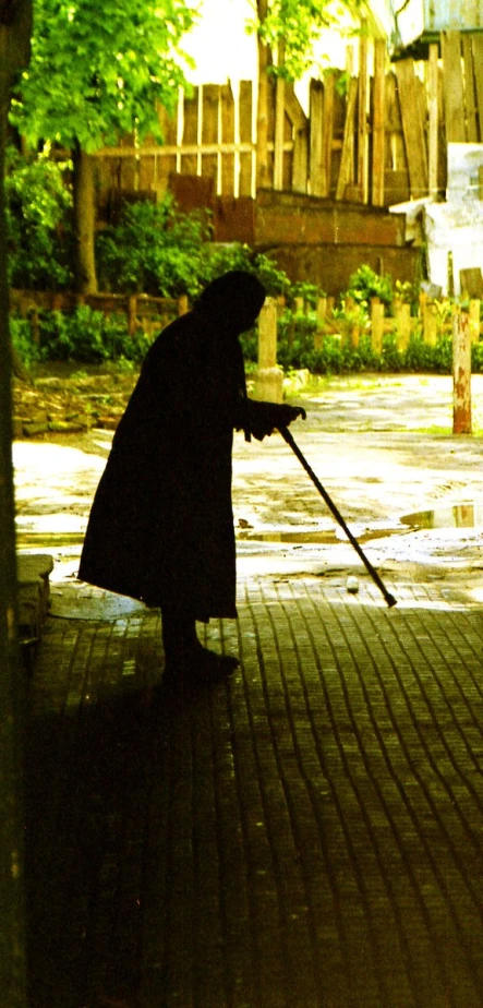 an old woman sweeping a sidewalk with a mop