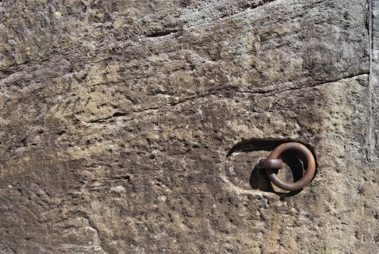 a metal ring is on the rocks wall